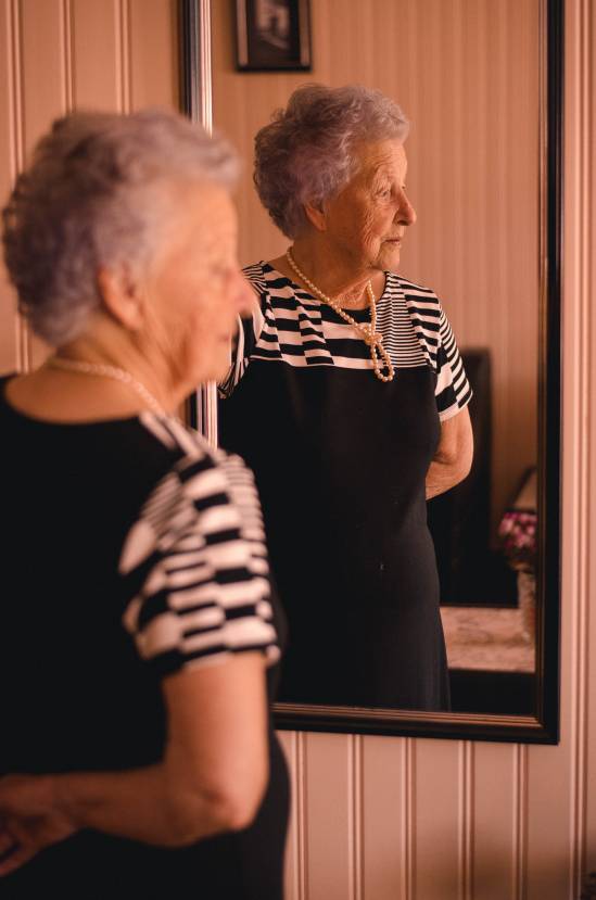 starsza kobieta przed lustrem