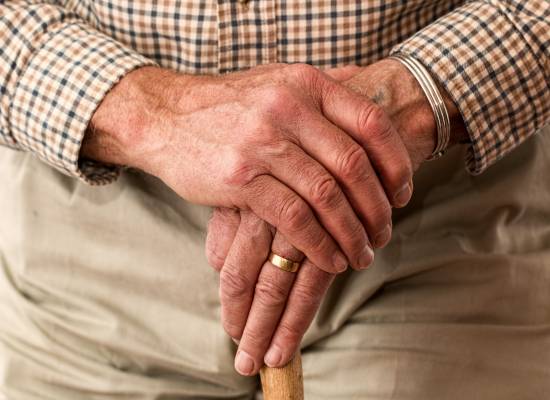 ręce starszego mężczyzny i laska ortopedyczna